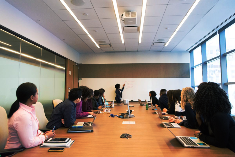 Conference room with multiple people looking at the far wall - SPSS Academia